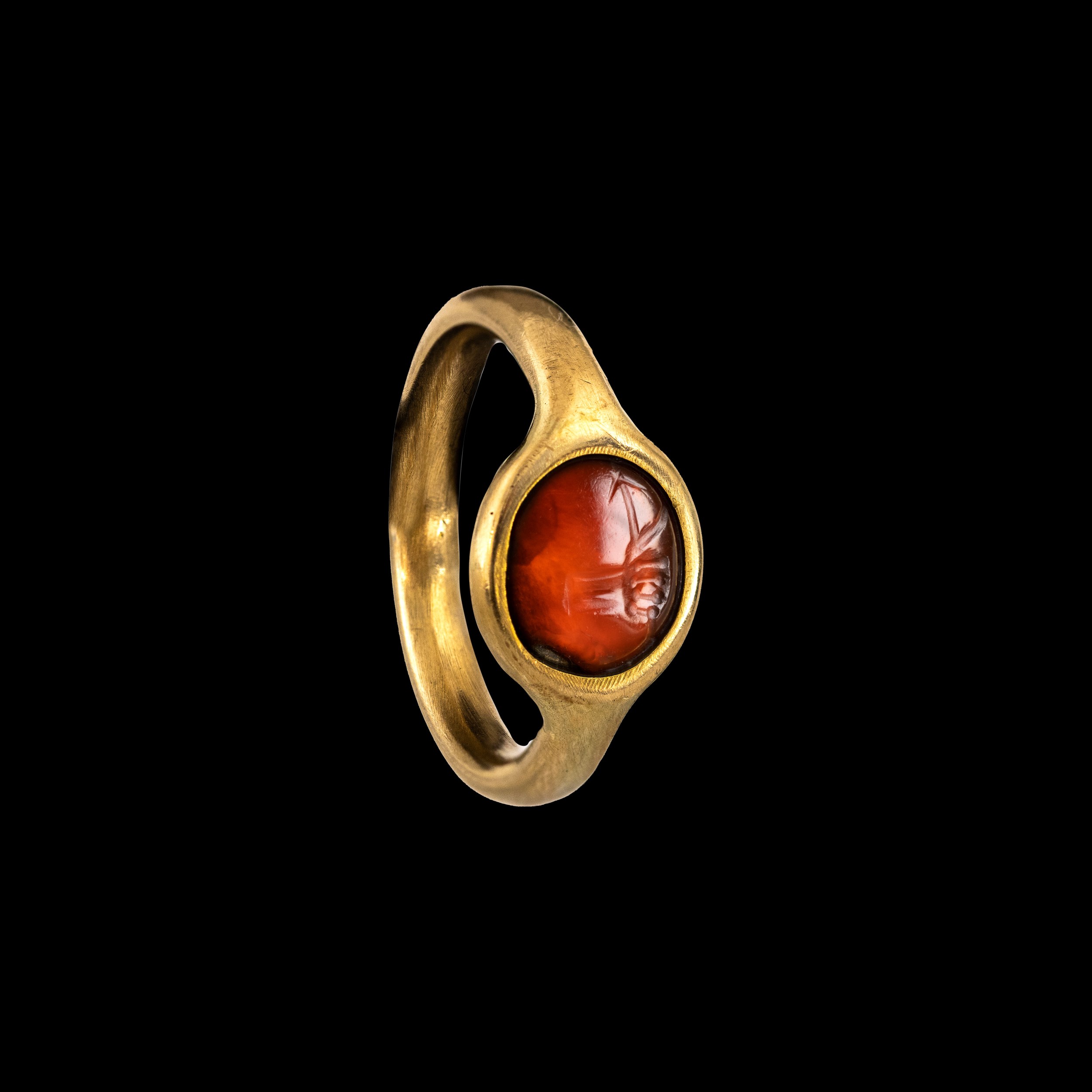 A gold ring set with an Italic carnelian intaglio. Hand with attributes. 